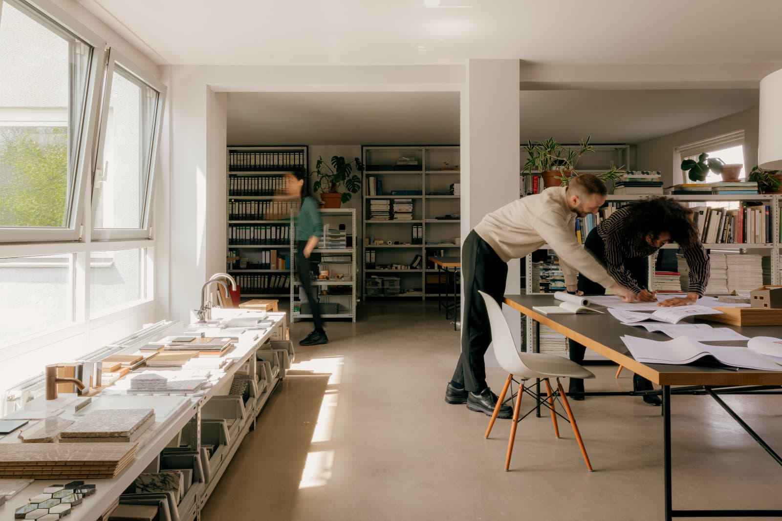 A team working with material samples and drawings in a bright studio.